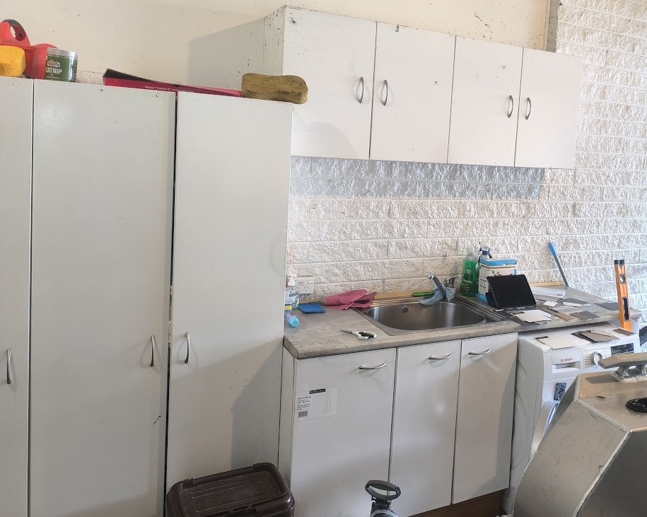 Laundry area before custom Cabinet Ninja storage was installed